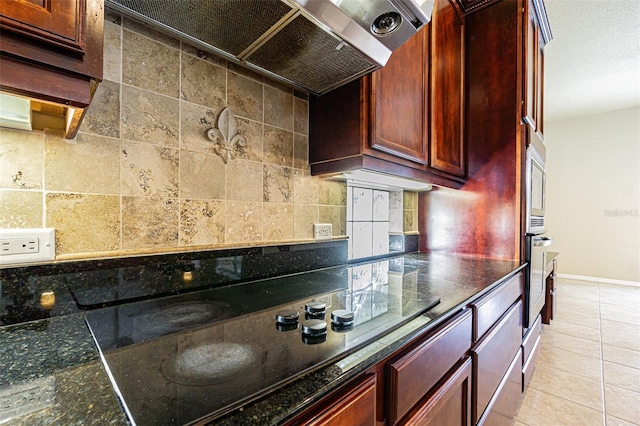 kitchen featuring tasteful backsplash, baseboards, black electric stovetop, dark brown cabinets, and light tile patterned flooring