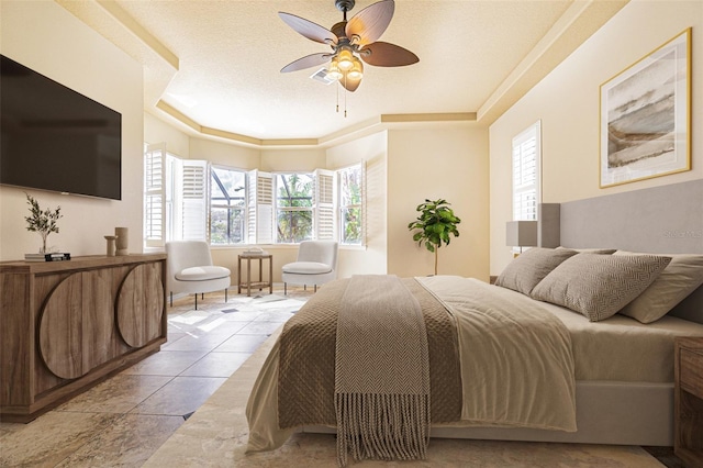 tiled bedroom featuring a tray ceiling, ceiling fan, visible vents, and a textured ceiling