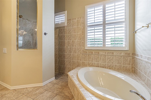 full bathroom featuring a garden tub, tile patterned flooring, baseboards, and tiled shower