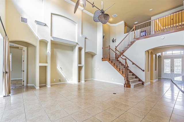 foyer entrance featuring arched walkways, french doors, visible vents, and stairs