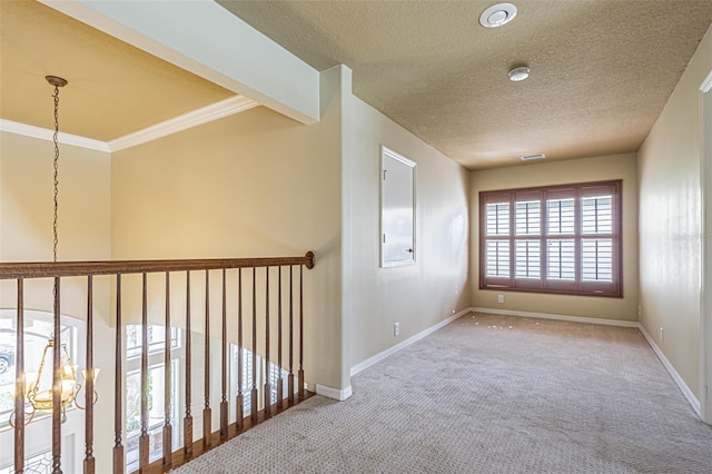 hall with a textured ceiling, a notable chandelier, carpet flooring, and baseboards