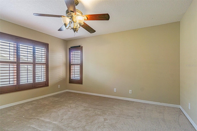 carpeted empty room featuring a ceiling fan, baseboards, and a textured ceiling