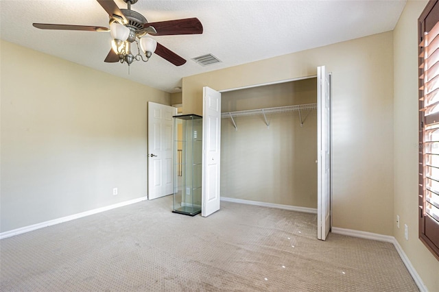 unfurnished bedroom with baseboards, visible vents, a closet, and light colored carpet