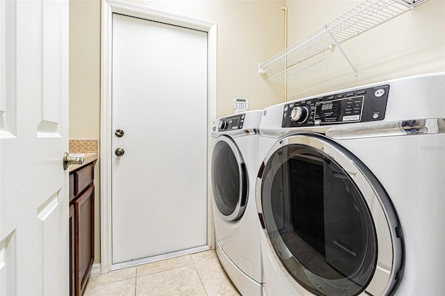 clothes washing area with laundry area, washer and clothes dryer, and light tile patterned flooring