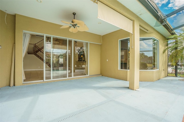 view of patio featuring a lanai and a ceiling fan