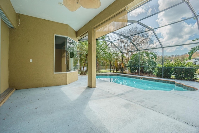 pool featuring glass enclosure, a patio, and ceiling fan