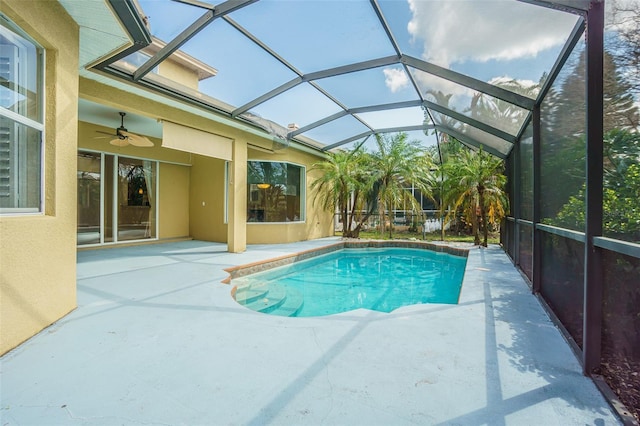 pool with a ceiling fan, glass enclosure, and a patio