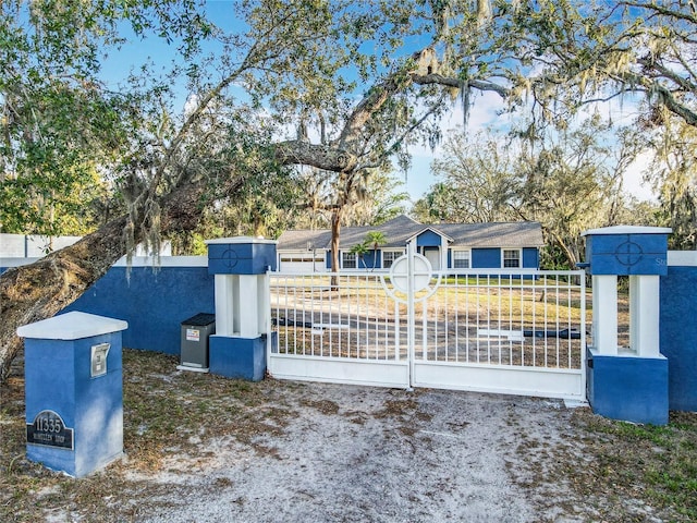 ranch-style home featuring a fenced front yard, a gate, and stucco siding