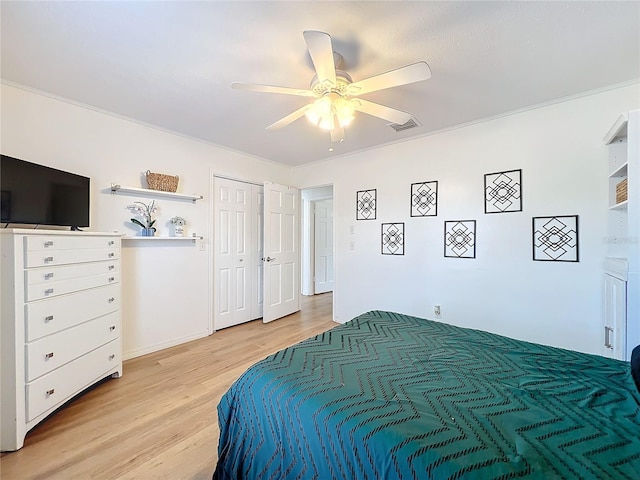 bedroom featuring light wood-style floors, ornamental molding, and a ceiling fan