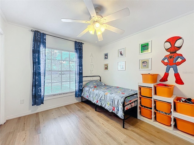 bedroom featuring ornamental molding, a ceiling fan, baseboards, and wood finished floors