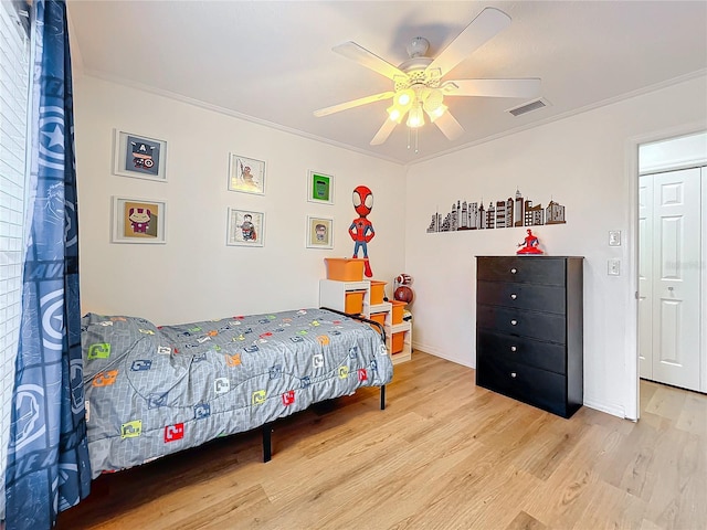 bedroom with wood finished floors, a ceiling fan, baseboards, visible vents, and crown molding