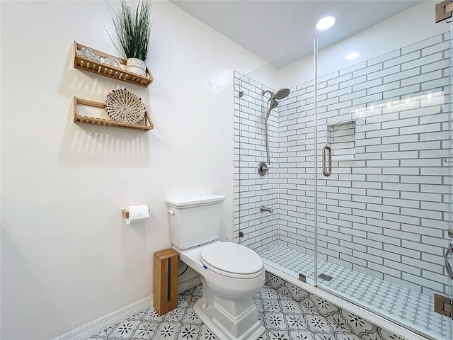 bathroom with baseboards, a shower stall, toilet, and tile patterned floors