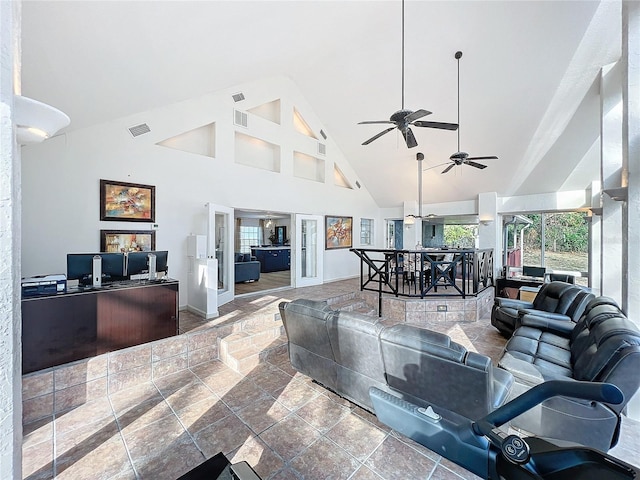 living area with high vaulted ceiling, stone tile flooring, and visible vents