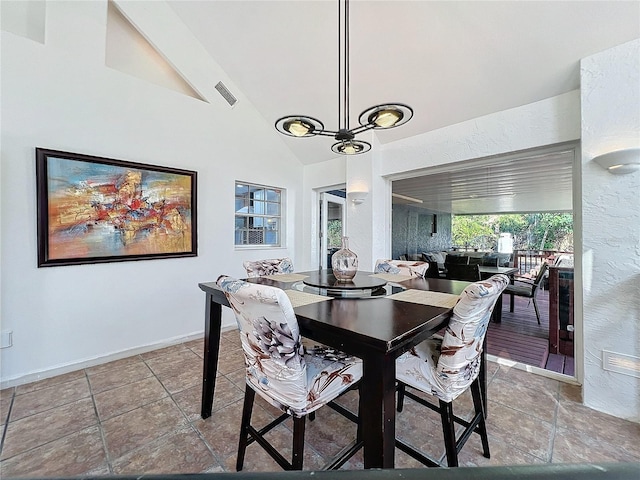 tiled dining area with lofted ceiling, baseboards, and visible vents