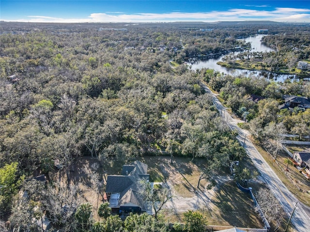 birds eye view of property featuring a water view and a wooded view