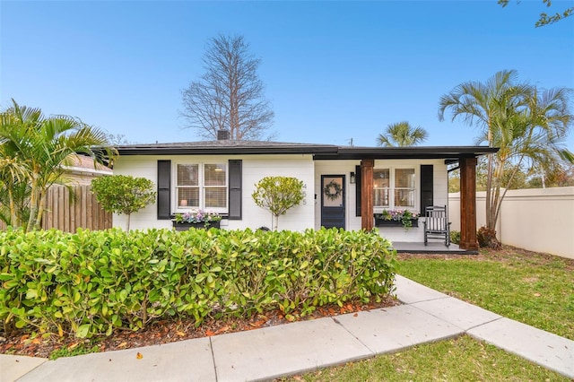 view of front of property with a porch and fence