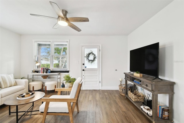 living area featuring ceiling fan, baseboards, and wood finished floors