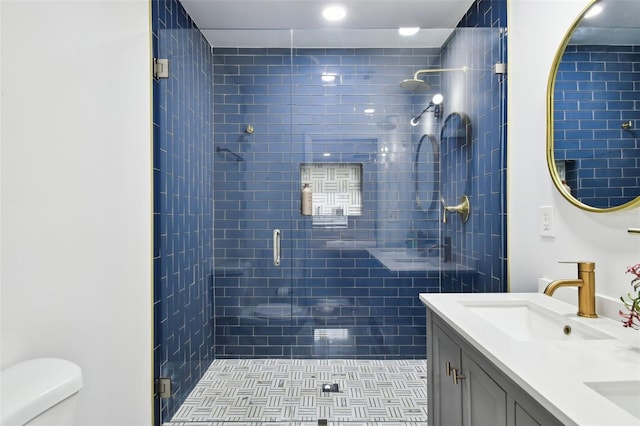 full bathroom featuring a stall shower, a sink, toilet, and double vanity