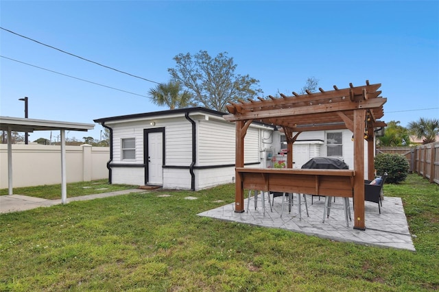 view of yard with a patio area, a fenced backyard, a pergola, and an outdoor structure