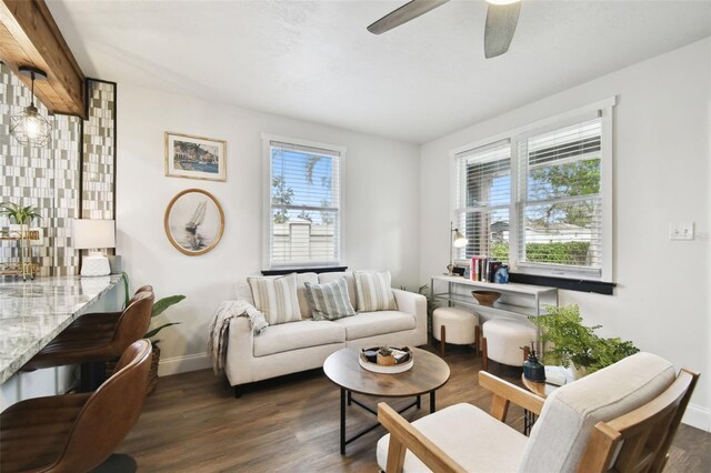 living room featuring a healthy amount of sunlight, ceiling fan, baseboards, and wood finished floors