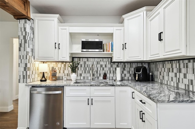 kitchen with white cabinets, decorative backsplash, stainless steel appliances, and a sink