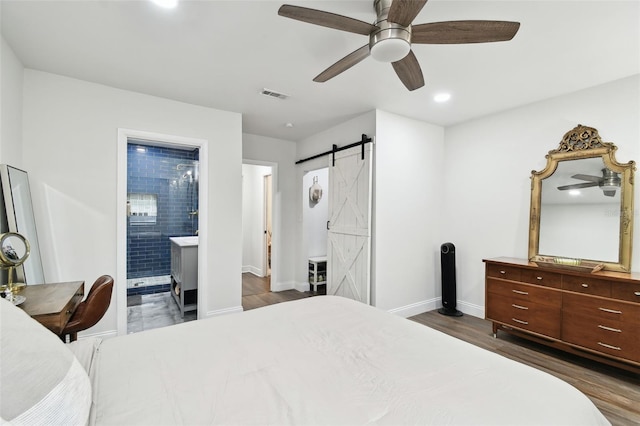 bedroom featuring a barn door, baseboards, visible vents, dark wood-style flooring, and recessed lighting