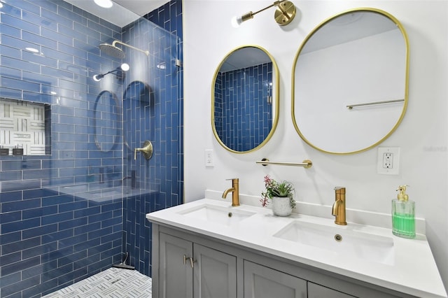 bathroom with double vanity, tiled shower, and a sink