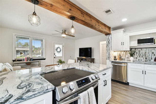 kitchen featuring stainless steel appliances, a sink, visible vents, decorative backsplash, and beamed ceiling