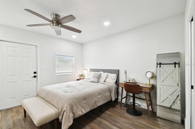 bedroom featuring ceiling fan, a barn door, wood finished floors, and recessed lighting