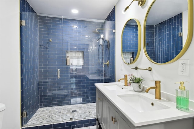 full bathroom with a sink, a shower stall, toilet, and double vanity