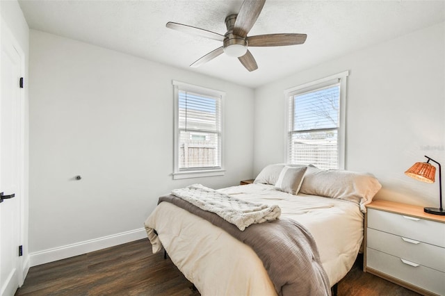 bedroom with dark wood-style floors, ceiling fan, and baseboards