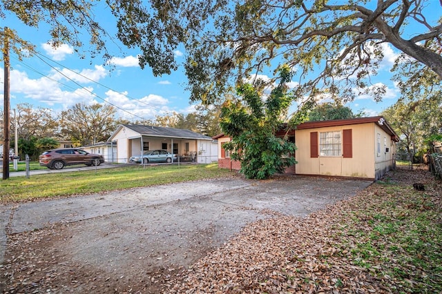 view of front of home with driveway, a front yard, and fence