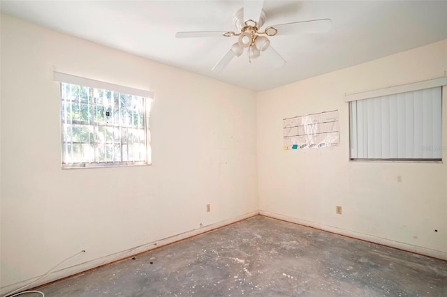 empty room featuring ceiling fan and baseboards