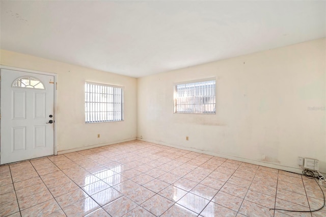 entryway with light tile patterned floors and baseboards