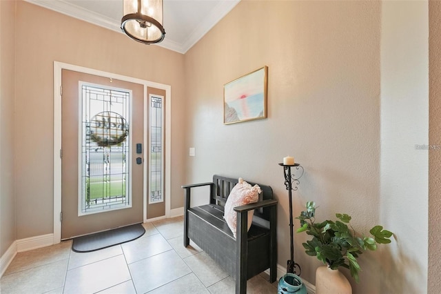 foyer with light tile patterned floors, ornamental molding, and baseboards