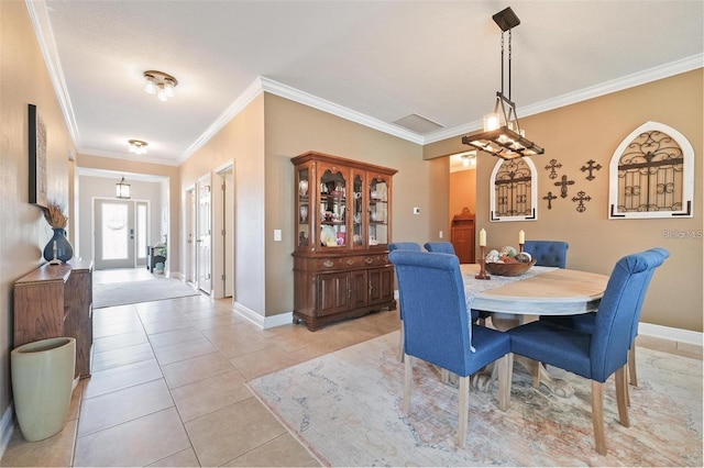 dining room featuring crown molding, baseboards, and light tile patterned floors