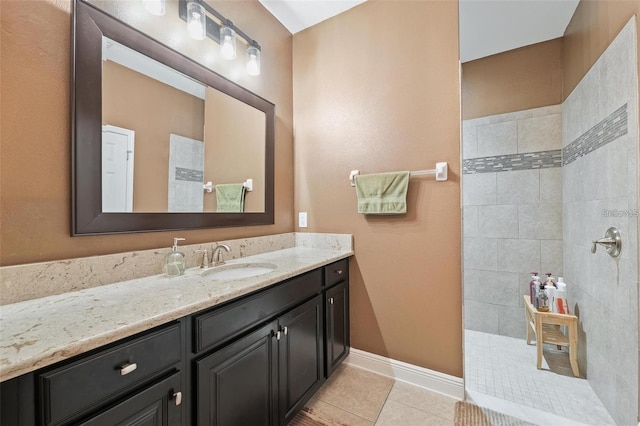 bathroom featuring baseboards, walk in shower, vanity, and tile patterned floors