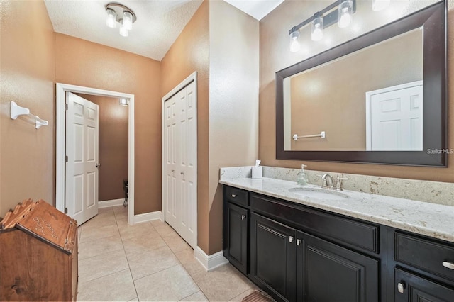 bathroom with vanity, baseboards, and tile patterned floors