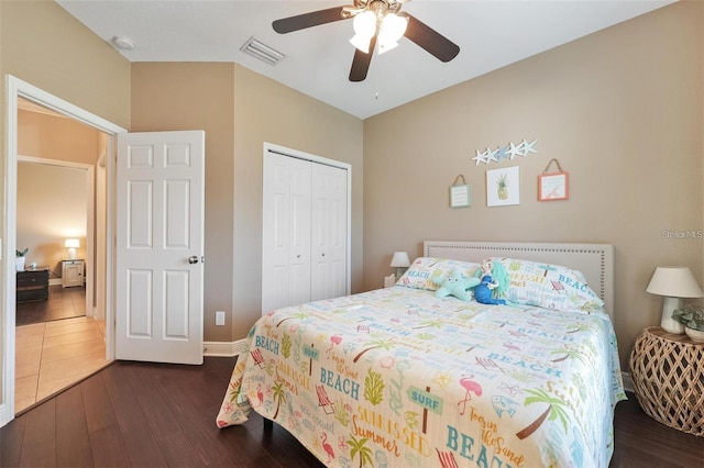 bedroom with ceiling fan, visible vents, baseboards, a closet, and dark wood-style floors