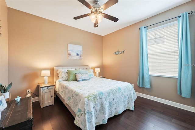 bedroom with ceiling fan, dark wood-type flooring, and baseboards