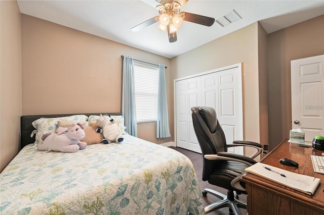 bedroom featuring a closet, visible vents, ceiling fan, and wood finished floors