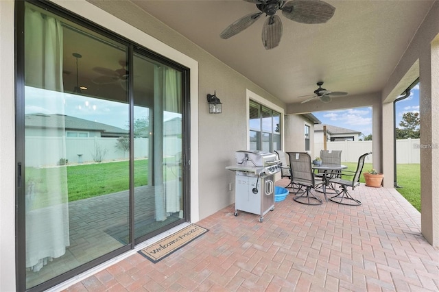 view of patio / terrace with a grill, fence, a ceiling fan, and outdoor dining space