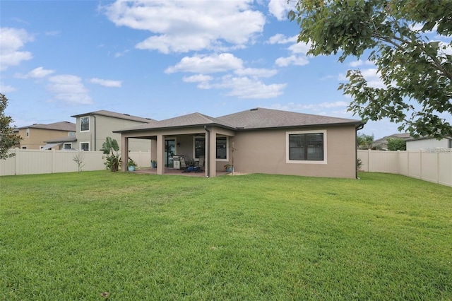 back of property featuring a patio, a yard, a fenced backyard, and stucco siding