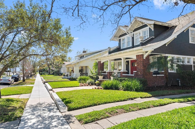 view of front facade with a residential view, brick siding, and a front lawn