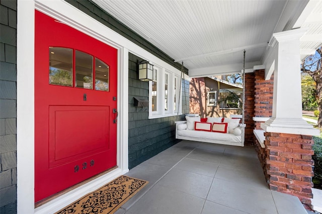 view of exterior entry featuring covered porch