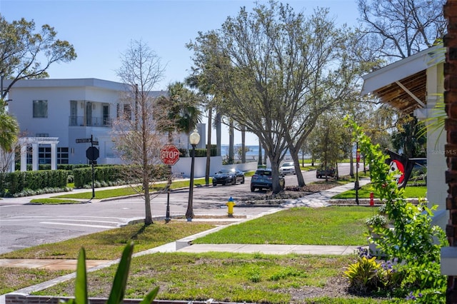 view of road featuring sidewalks, curbs, and traffic signs