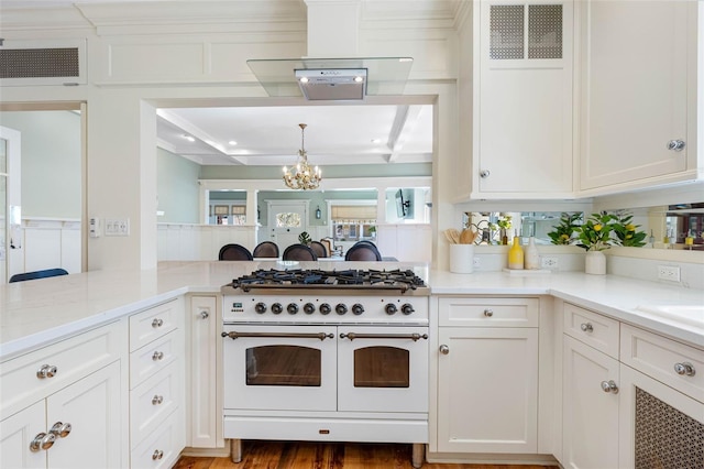 kitchen featuring double oven range, light stone countertops, visible vents, and white cabinetry