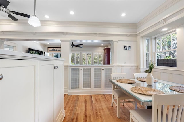 dining area featuring crown molding, plenty of natural light, and light wood-type flooring