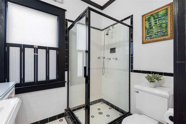 bathroom featuring a shower stall, toilet, and tile walls