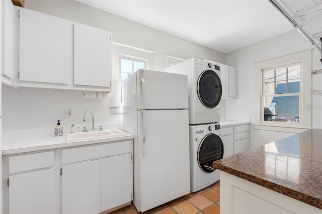 washroom with a sink, laundry area, and stacked washing maching and dryer